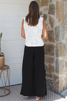 Black wide-leg rayon pants with elastic waist, front tie and side pockets