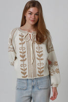 Woman wearing cream boho knit jumper with golden lurex detailing, balloon sleeves and relaxed winter styling.