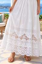 Lola white embroidered cotton maxi dress by Salty Palm featuring floral cutwork, adjustable straps, fitted waist and scalloped lace hem.