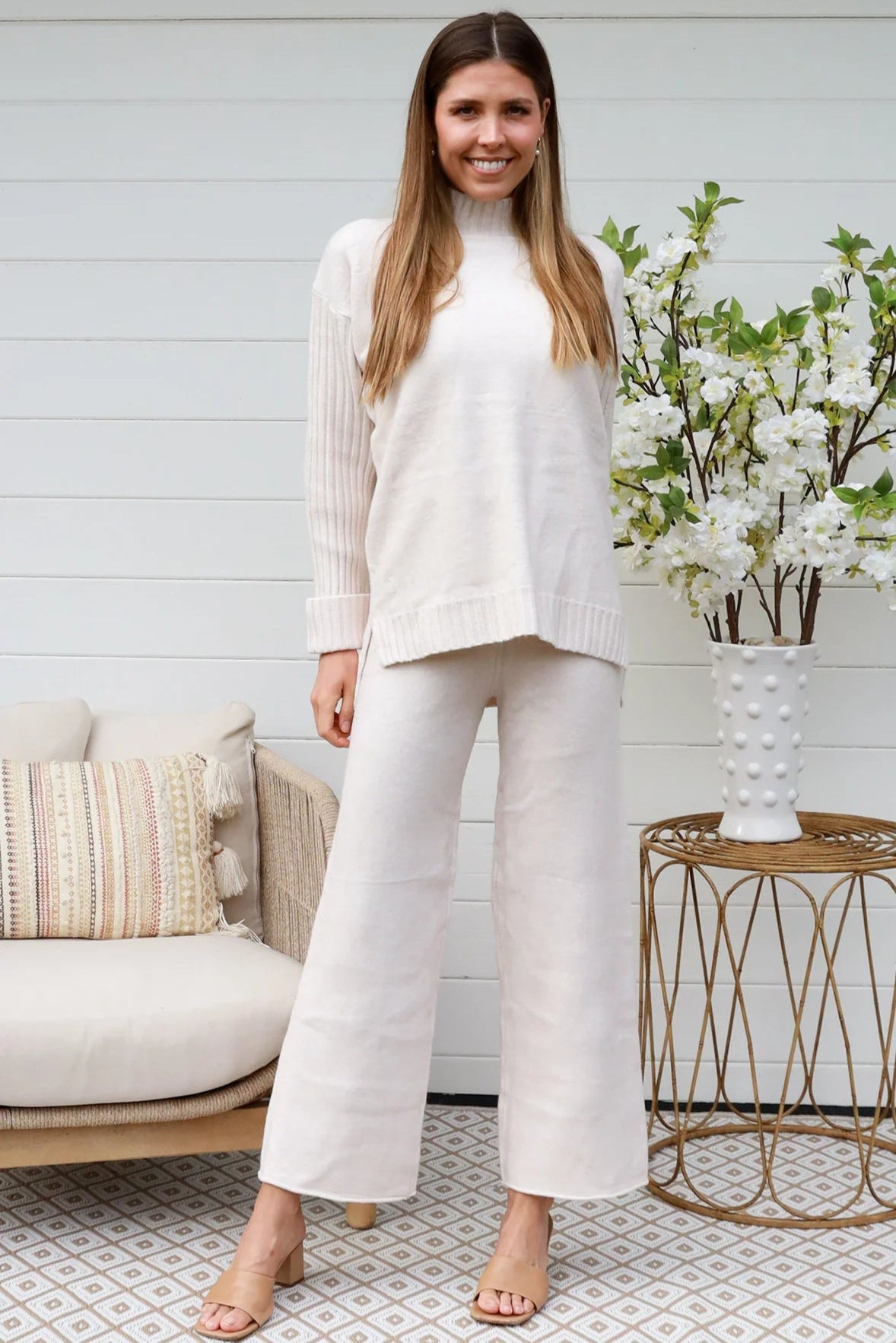 Model wearing cream knit lounge set with high-neck jumper and wide-leg pants - women's loungewear Australia.