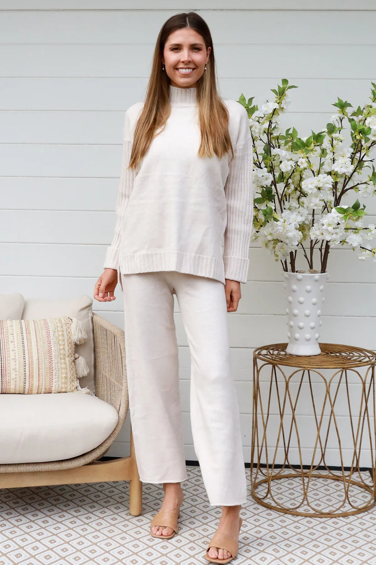 Model wearing cream knit lounge set with high-neck jumper and wide-leg pants - women's loungewear Australia.