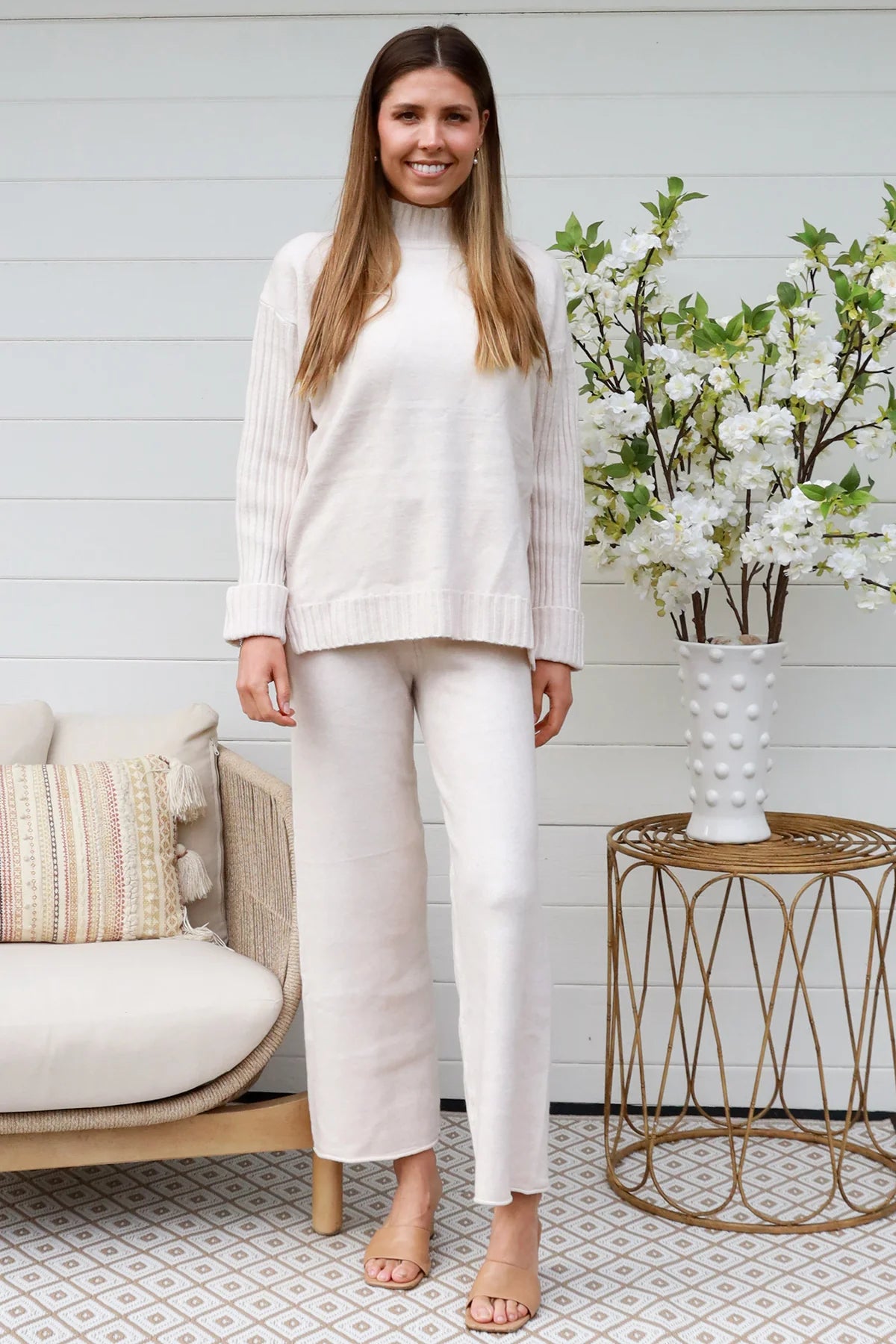 Model wearing cream knit lounge set with high-neck jumper and wide-leg pants - women's loungewear Australia.