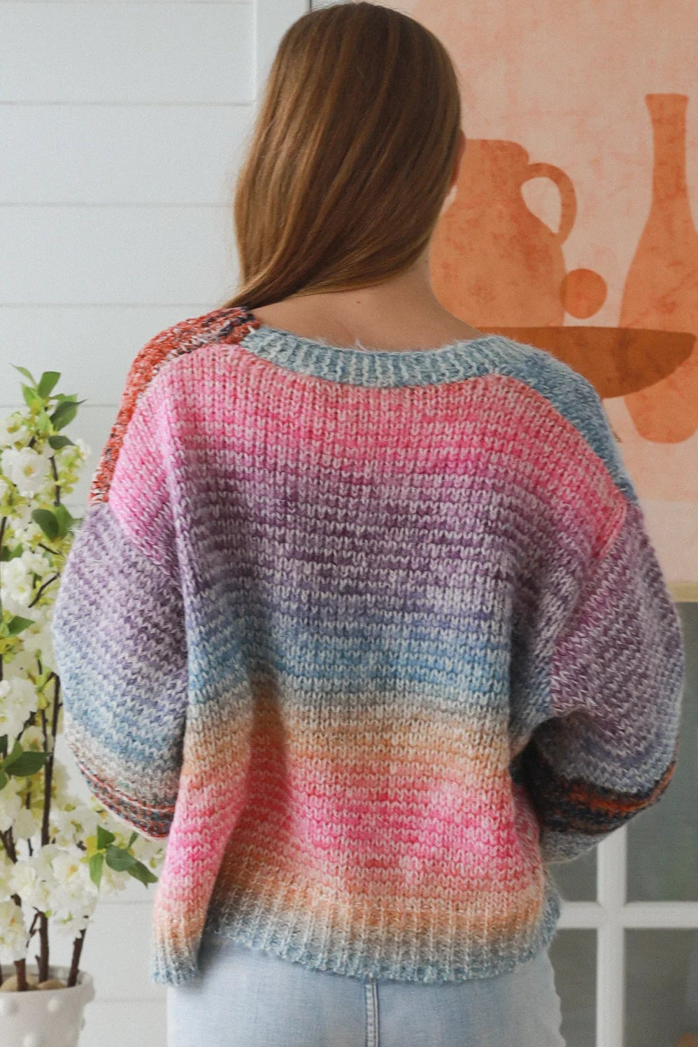 Woman wearing pastel stripe wool blend knit jumper with denim jeans and relaxed boho winter styling