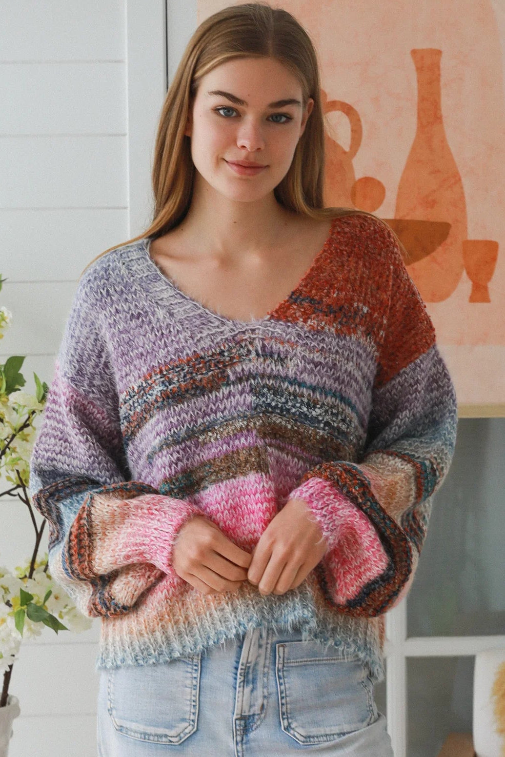 Woman wearing pastel stripe wool blend knit jumper with denim jeans and relaxed boho winter styling