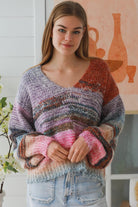 Woman wearing pastel stripe wool blend knit jumper with denim jeans and relaxed boho winter styling