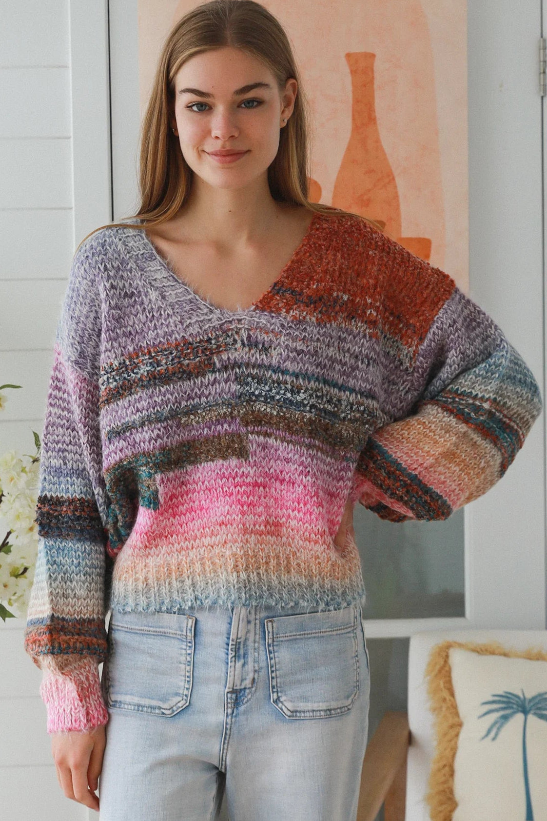 Woman wearing pastel stripe wool blend knit jumper with denim jeans and relaxed boho winter styling