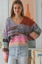 Woman wearing pastel stripe wool blend knit jumper with denim jeans and relaxed boho winter styling