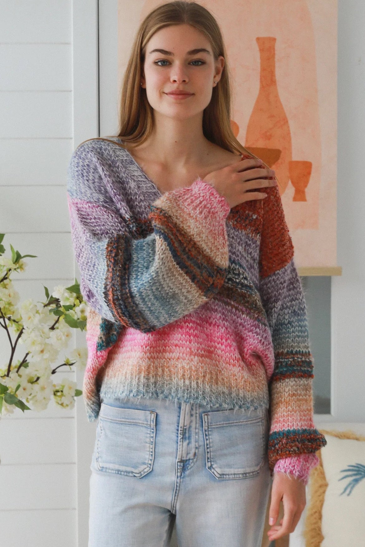 Woman wearing pastel stripe wool blend knit jumper with denim jeans and relaxed boho winter styling