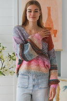 Woman wearing pastel stripe wool blend knit jumper with denim jeans and relaxed boho winter styling
