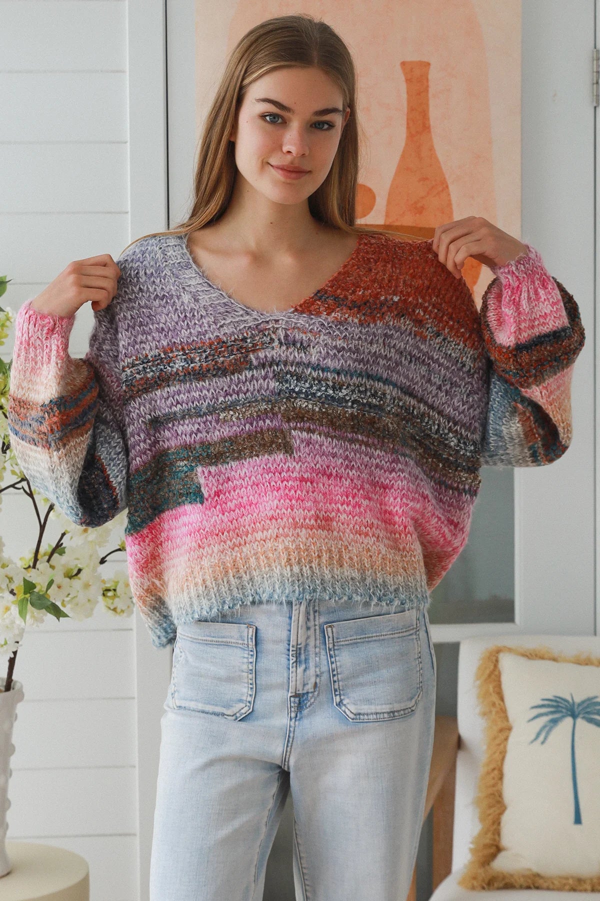 Woman wearing pastel stripe wool blend knit jumper with denim jeans and relaxed boho winter styling