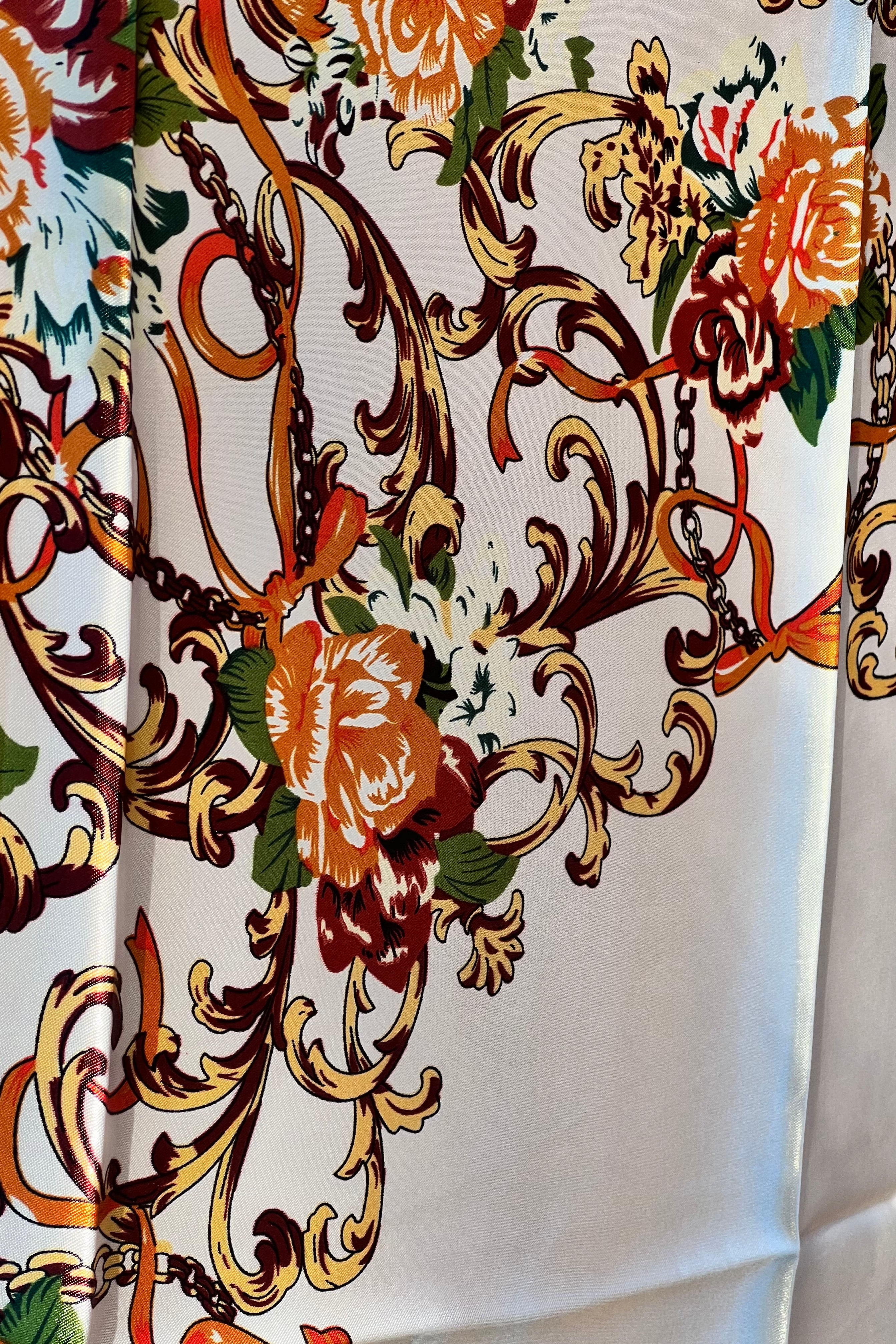 Brown satin square scarf with baroque floral print and red border in vintage-inspired warm tones.