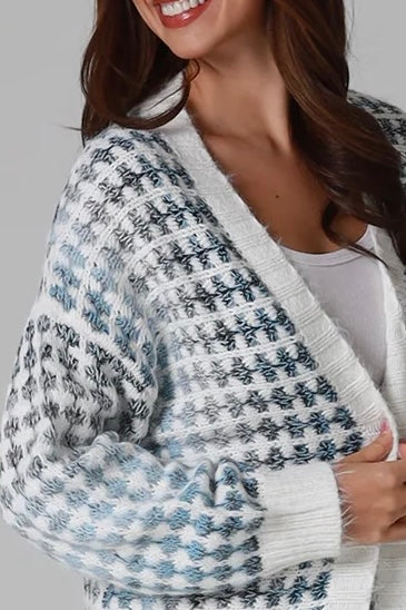 Woman wearing Juliet white and blue houndstooth longline fringe knit cardigan with drop shoulder sleeves, ribbed cuffs and front pockets by Charlotte The Label.
