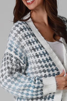 Woman wearing Juliet white and blue houndstooth longline fringe knit cardigan with drop shoulder sleeves, ribbed cuffs and front pockets by Charlotte The Label.