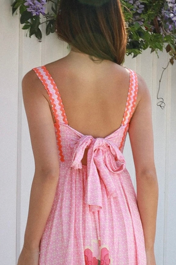 Woman wearing pink floral boho maxi dress with rickrack trim and oversized border hem – Salty Palm