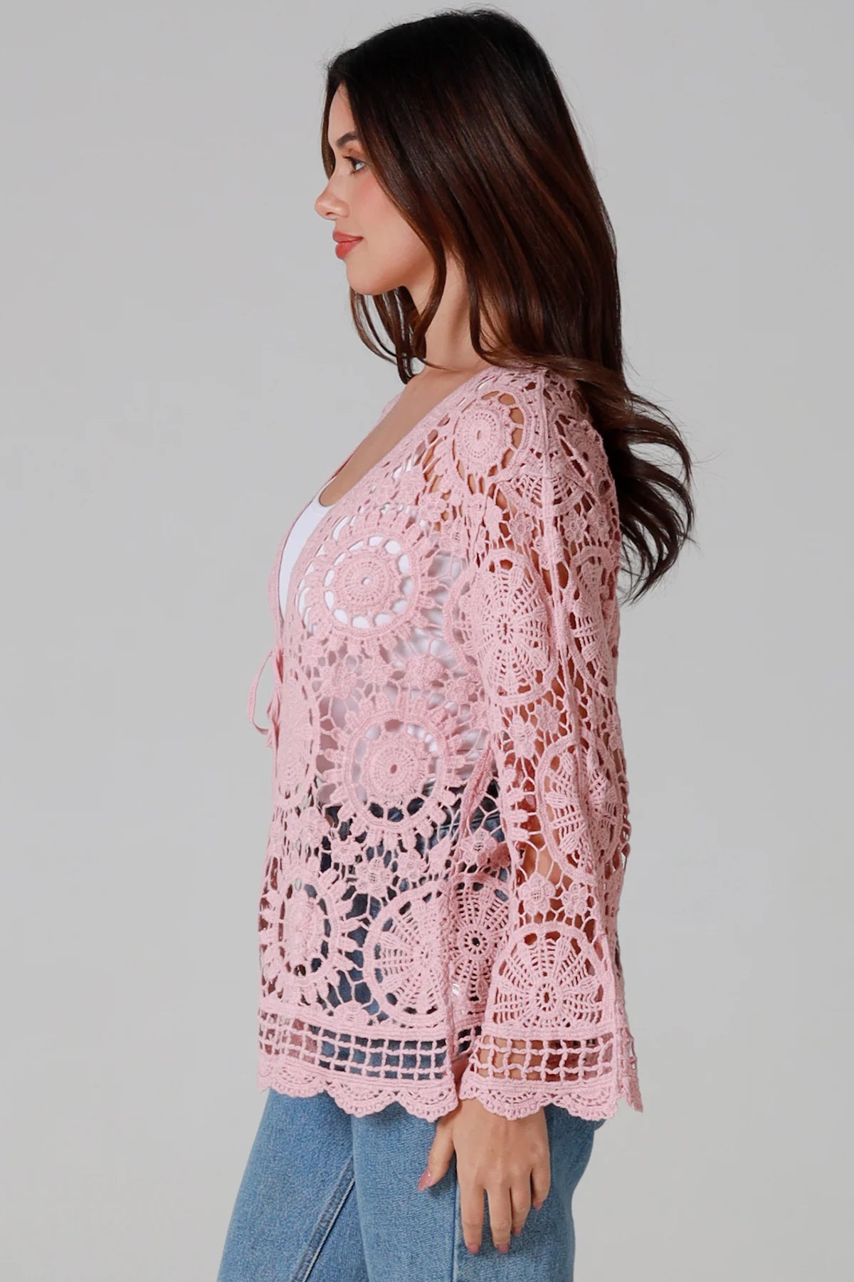 Women in blush pink cotton crochet cardigan with tie front and scalloped hem - boho chic cardigan Australia.