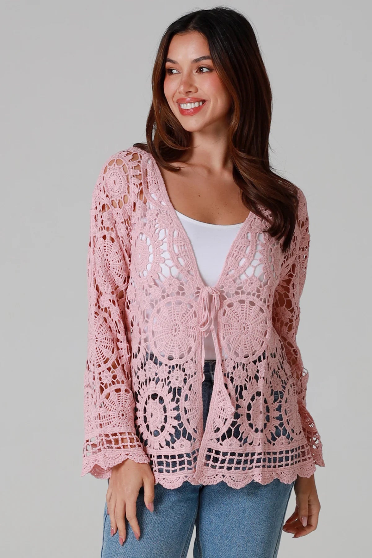 Women in blush pink cotton crochet cardigan with tie front and scalloped hem - boho chic cardigan Australia.