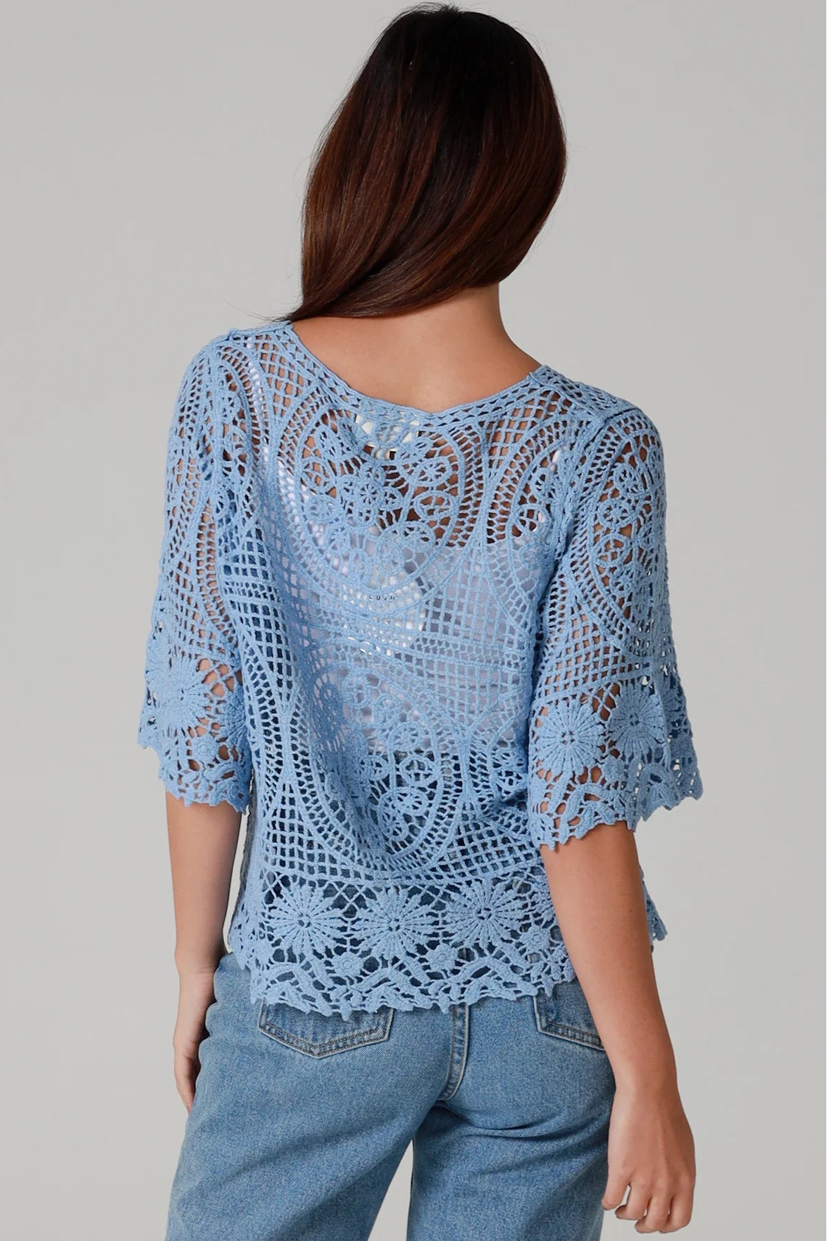 “Sky blue bohemian crochet cotton cardigan with scalloped sleeves and floral tie detail – boho knitwear Australia.”