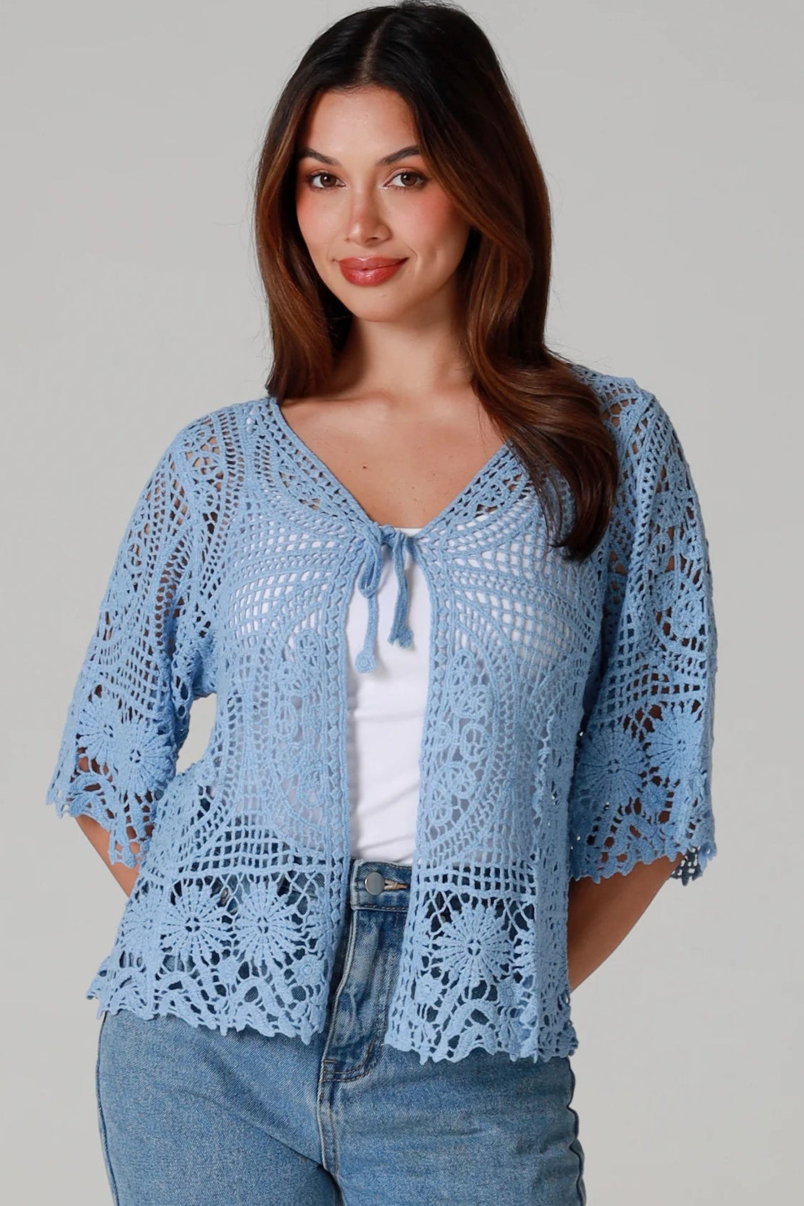 “Sky blue bohemian crochet cotton cardigan with scalloped sleeves and floral tie detail – boho knitwear Australia.”