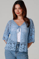 “Sky blue bohemian crochet cotton cardigan with scalloped sleeves and floral tie detail – boho knitwear Australia.”