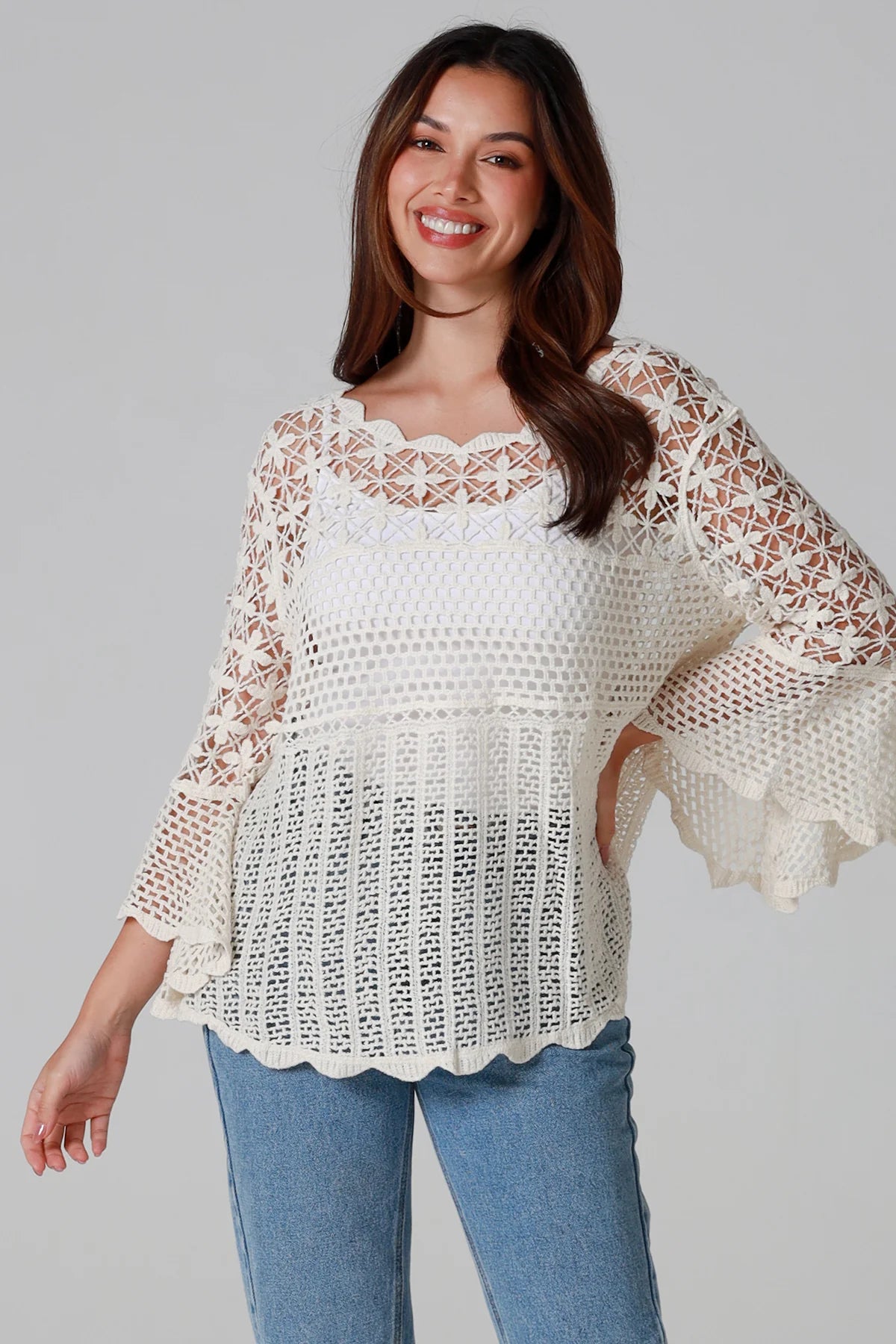 Woman wearing cream cotton crochet top with scalloped neckline and bell sleeves - Boho crochet blouse Australia.