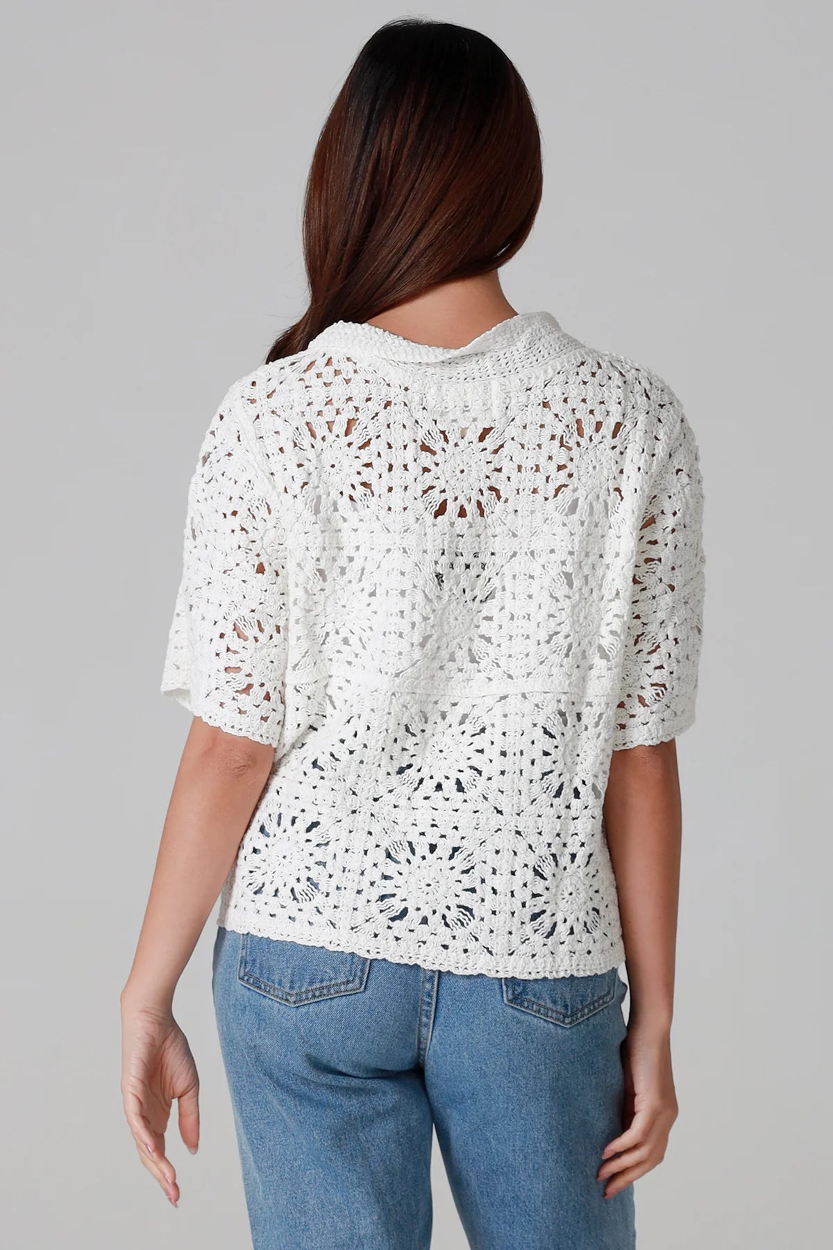 Woman wearing white cotton crochet cardigan with collar and buttons - boho knit top Australia.