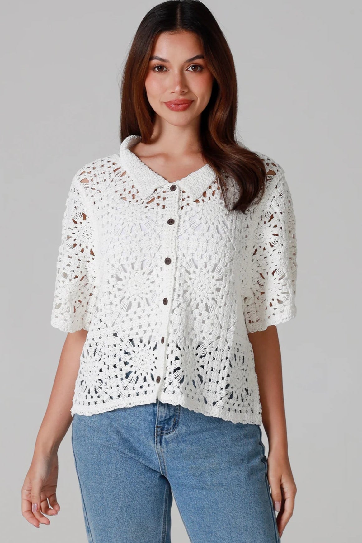 Woman wearing white cotton crochet cardigan with collar and buttons - boho knit top Australia.