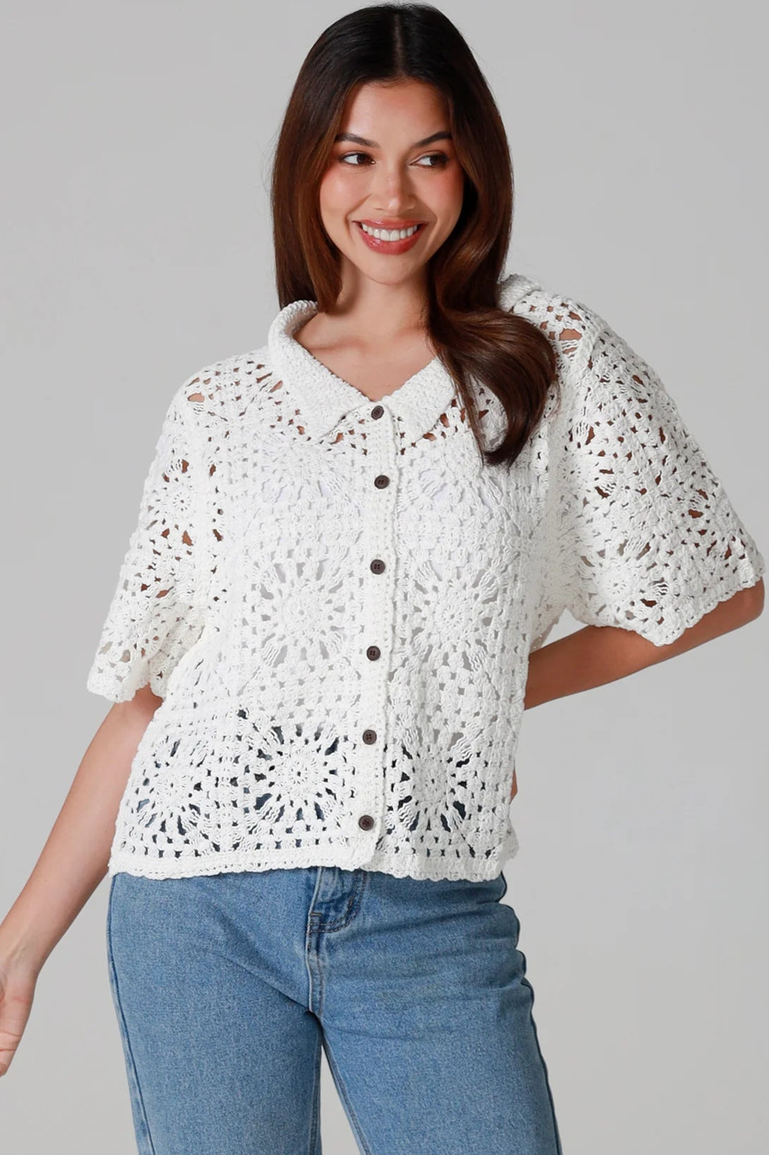 Woman wearing white cotton crochet cardigan with collar and buttons - boho knit top Australia.