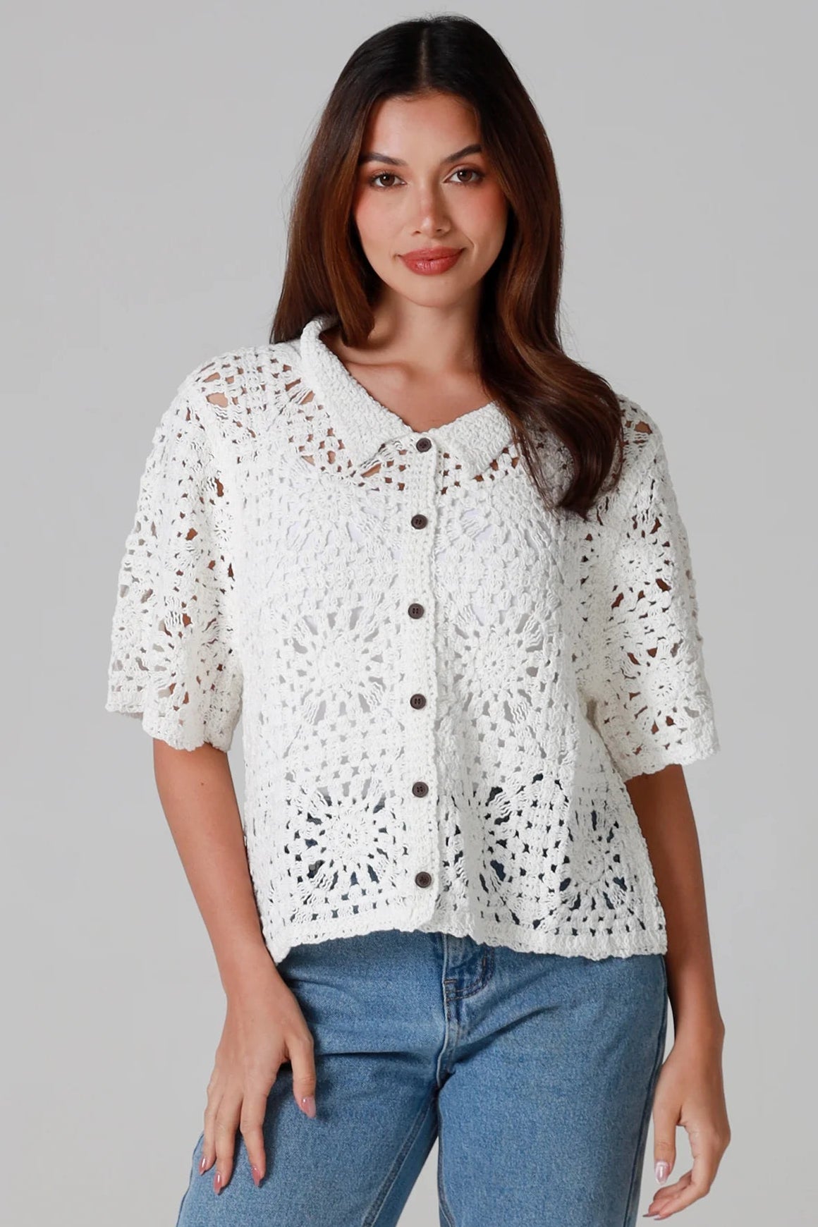 Woman wearing white cotton crochet cardigan with collar and buttons - boho knit top Australia.