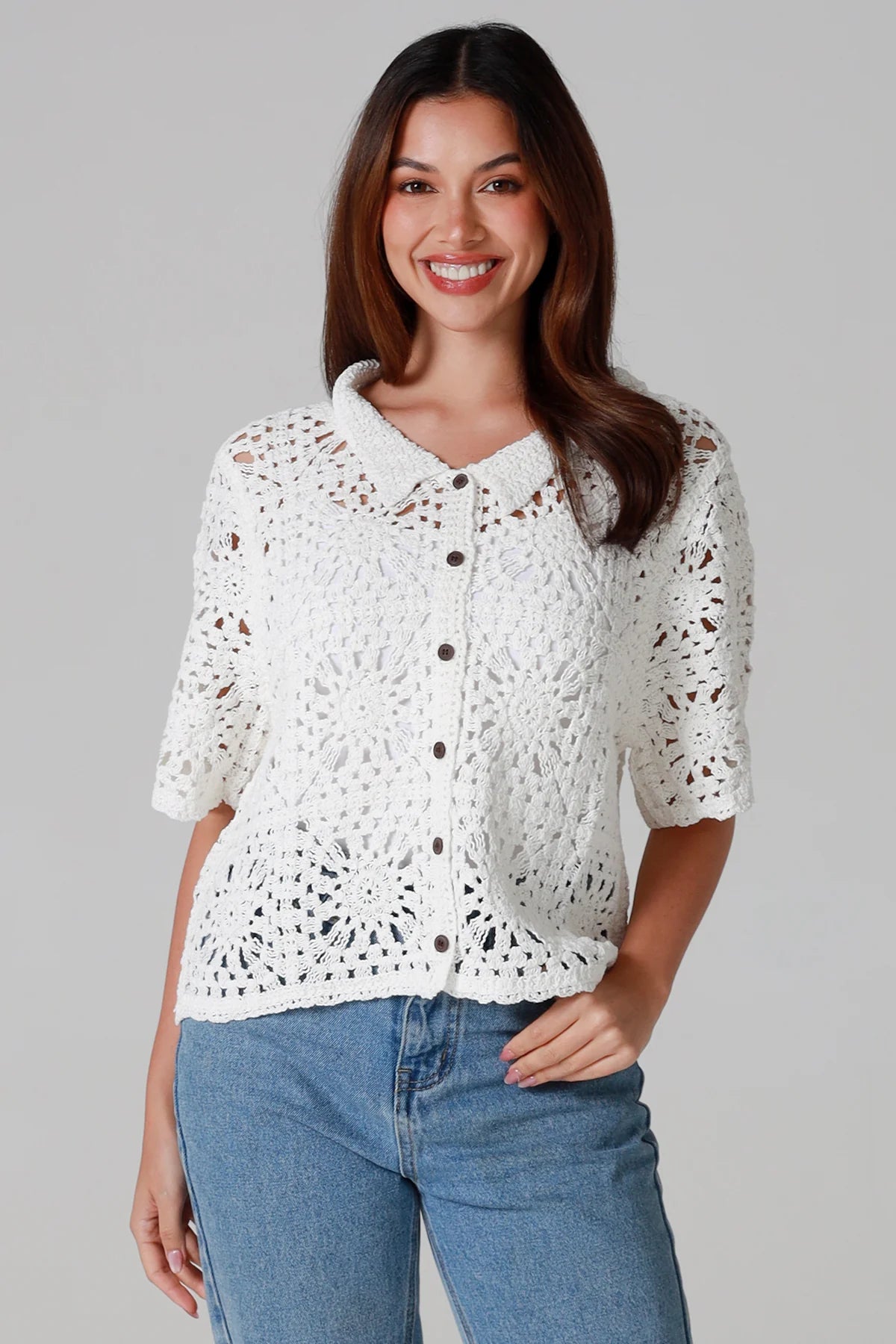 Woman wearing white cotton crochet cardigan with collar and buttons - boho knit top Australia.