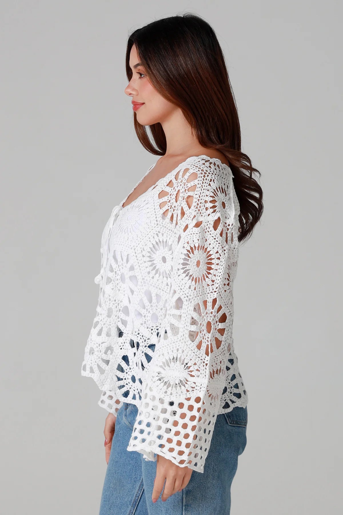 White crochet cardigan with tie front and boho bell sleeves layered over denim - crochet cardigan Australia.