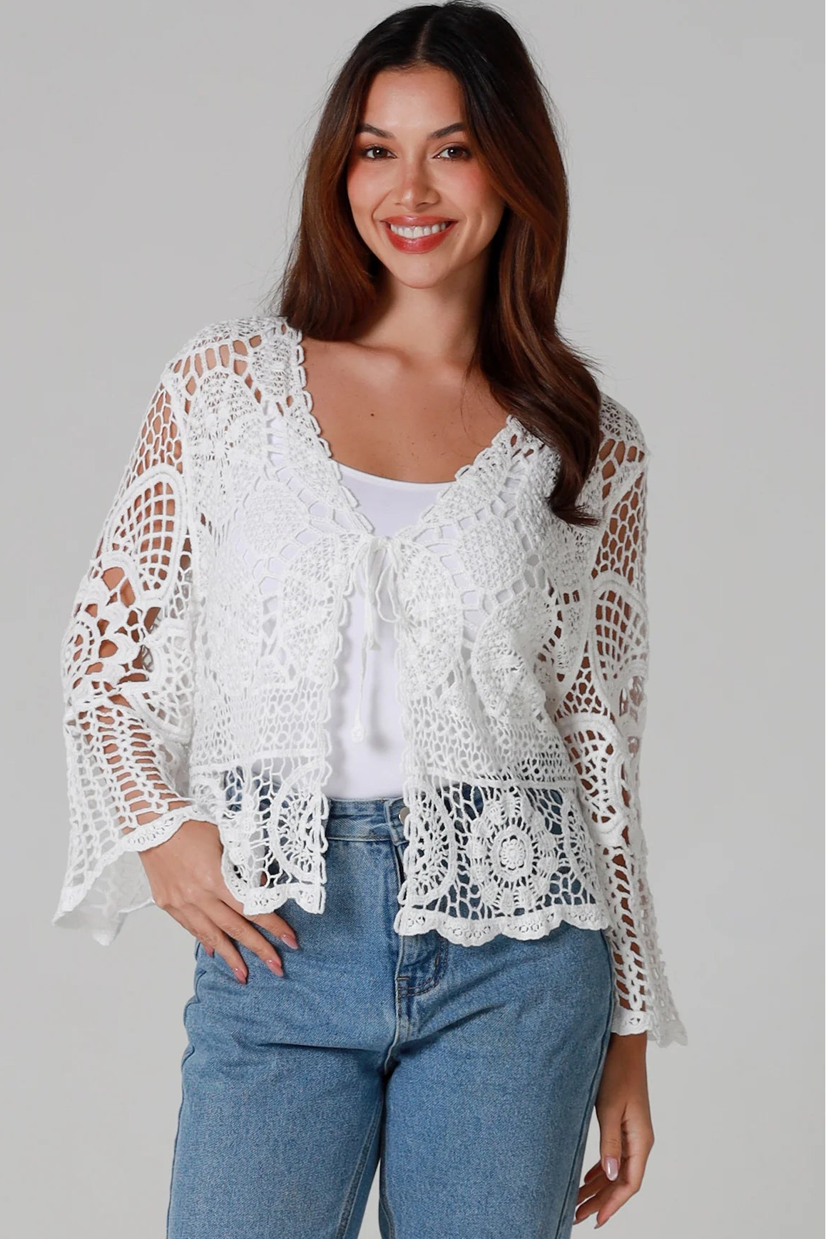 Woman in white cotton crochet embroidered top with flared sleeves and tie-front – Australian boho style