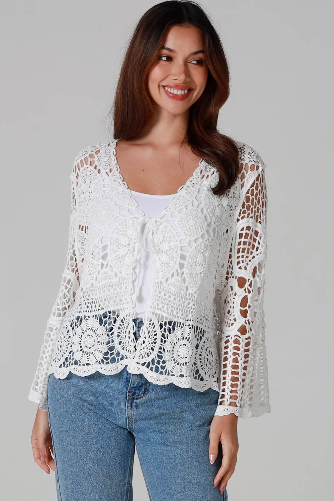 Woman in white cotton crochet embroidered top with flared sleeves and tie-front – Australian boho style