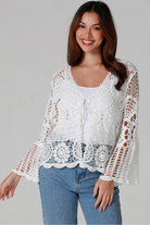 Woman in white cotton crochet embroidered top with flared sleeves and tie-front – Australian boho style