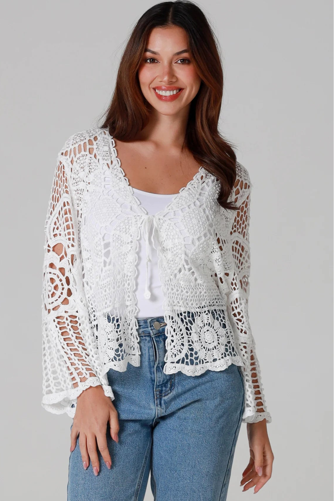 Woman in white cotton crochet embroidered top with flared sleeves and tie-front – Australian boho style