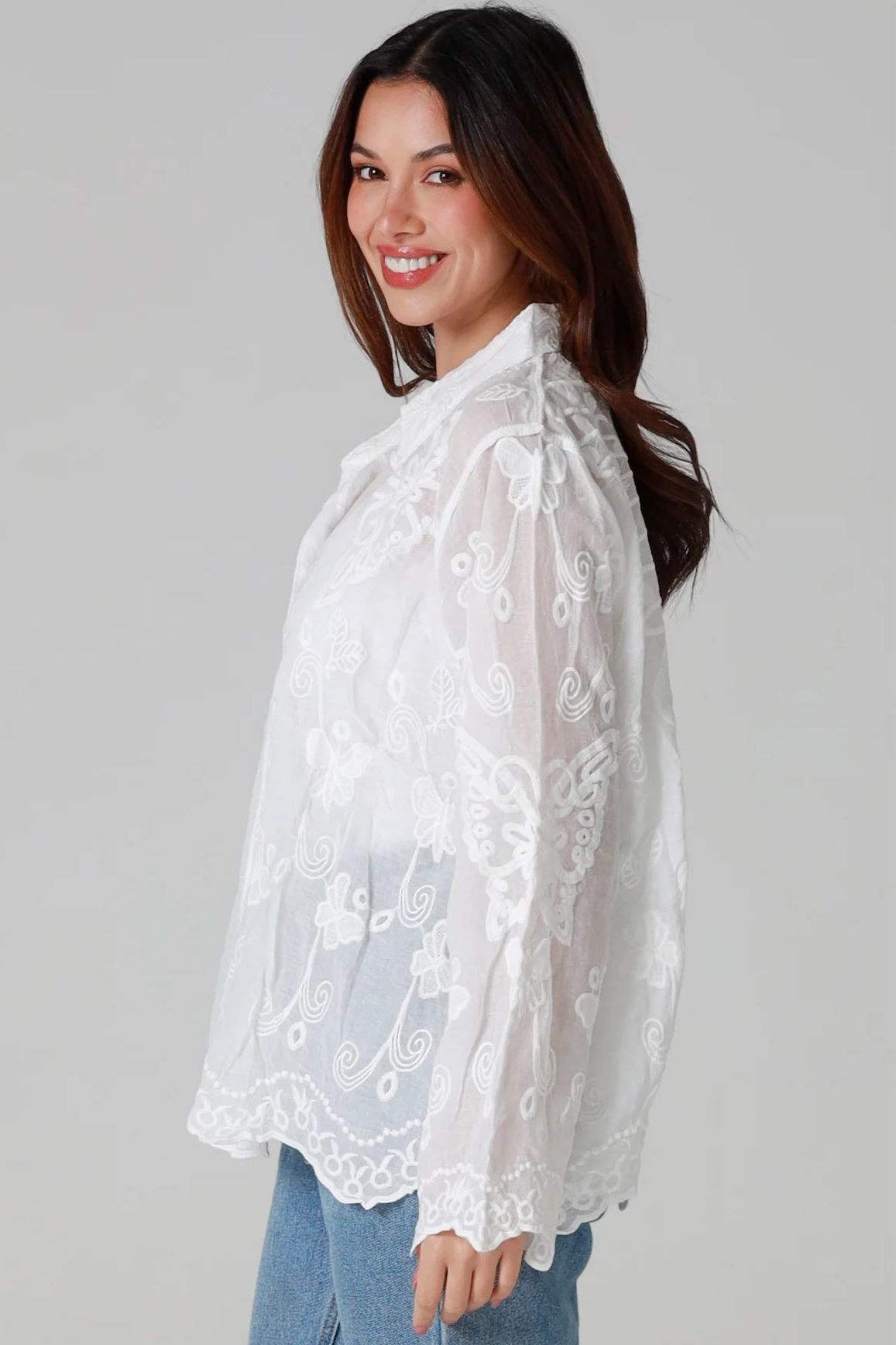 Woman in white cotton embroidered butterfly shirt with scalloped cuffs - boho blouse Australia.