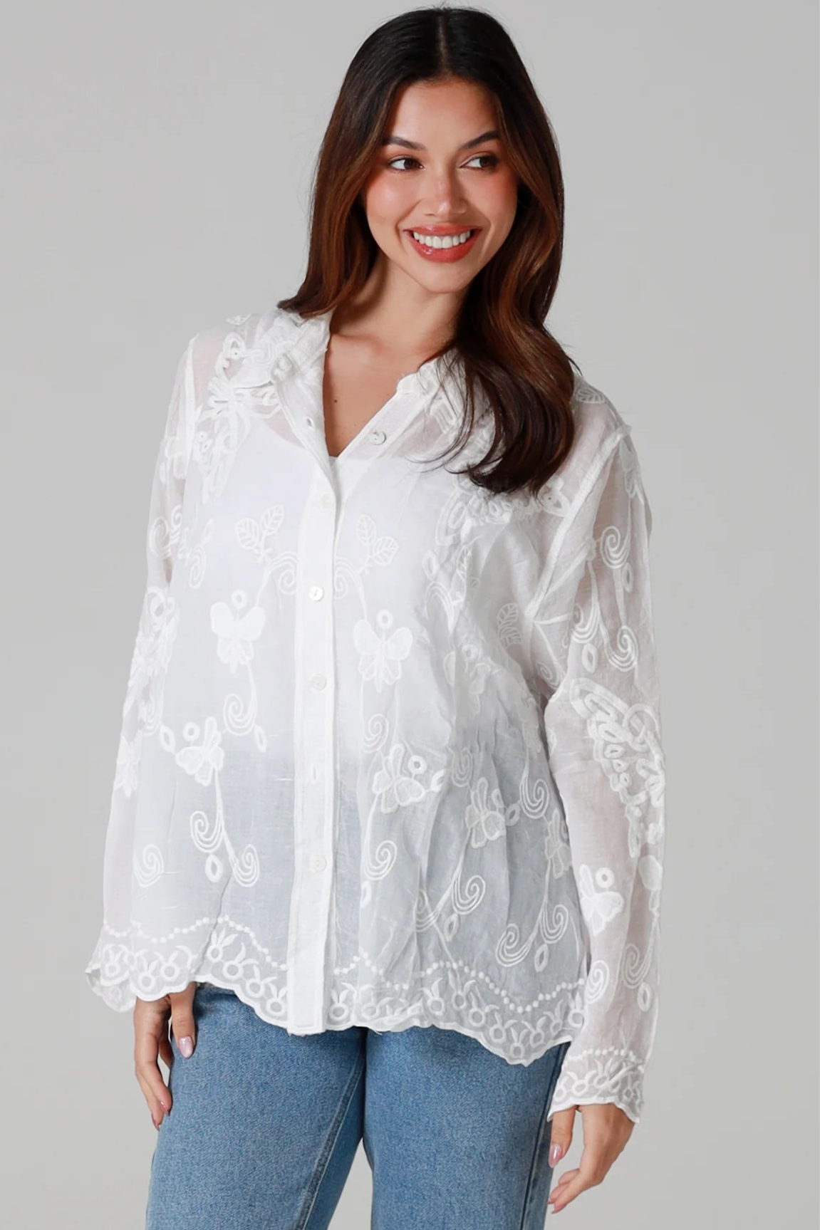 Woman in white cotton embroidered butterfly shirt with scalloped cuffs - boho blouse Australia.