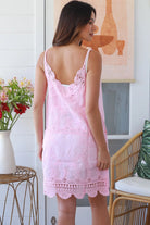 Woman in pink embroidered cotton mini dress with lace V-neck and scalloped hem – Bohemian Love Runway.