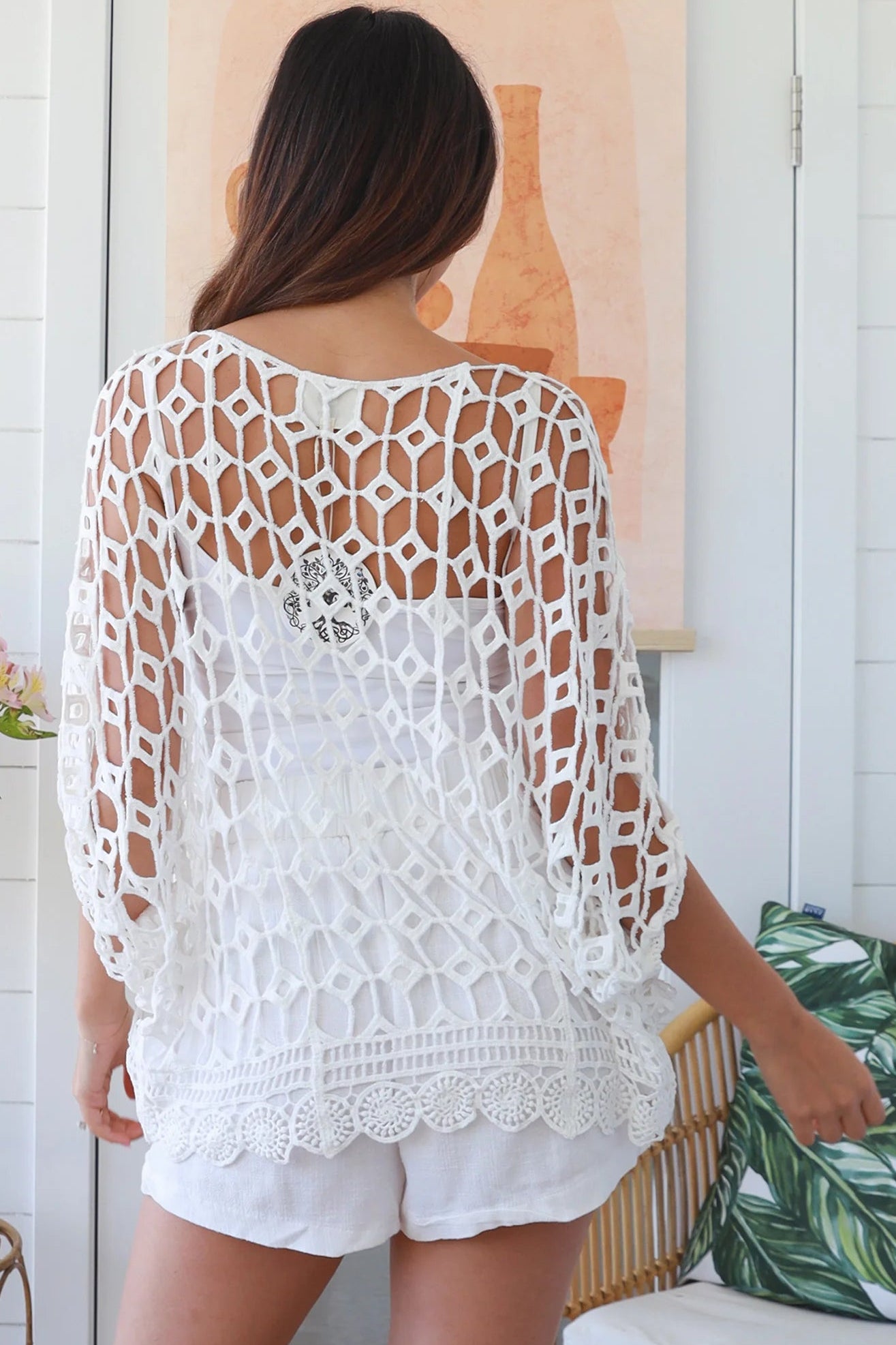 Woman wearing a white crochet cotton top with open-weave pattern, scalloped hem and batwing sleeves – Bohemian Love Runway