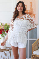 Woman wearing a white crochet cotton top with open-weave pattern, scalloped hem and batwing sleeves – Bohemian Love Runway