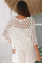 Woman wearing a white crochet cotton cardigan with diamond and floral pattern and scalloped sleeves - Boho Cardigan Australia