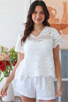 White cotton crochet top with mandala motifs scalloped sleeves and peplum hem – boho summer fashion