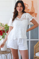 White cotton crochet top with mandala motifs scalloped sleeves and peplum hem – boho summer fashion