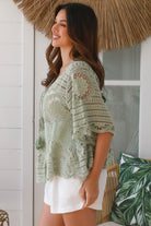 Woman in sage green cotton crochet top with embroidered floral lace and tassel ties - Olivia boho top Australia.