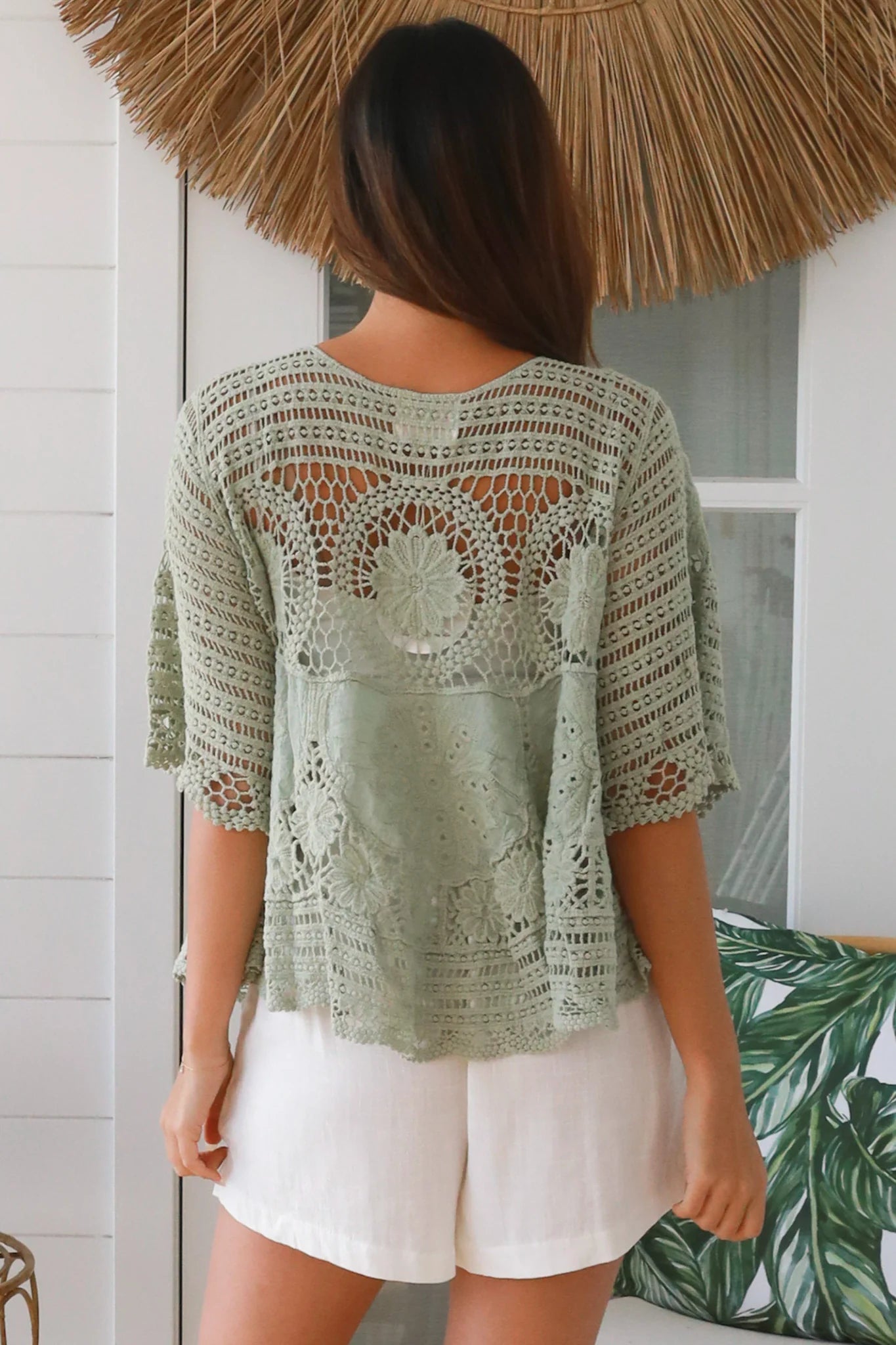 Woman in sage green cotton crochet top with embroidered floral lace and tassel ties - Olivia boho top Australia.