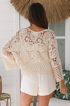 Woman wearing a cream crochet cotton jacket with bell sleeves and tie-front - boho layering piece Australia