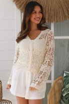 Bohemian woman in cream crochet cotton jacket with scalloped lace edges and button front - versatile boho jacket Australia