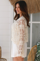 Bohemian woman in cream crochet cotton jacket with scalloped lace edges and button front - versatile boho jacket Australia