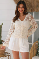 Bohemian woman in cream crochet cotton jacket with scalloped lace edges and button front - versatile boho jacket Australia