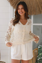 Bohemian woman in cream crochet cotton jacket with scalloped lace edges and button front - versatile boho jacket Australia