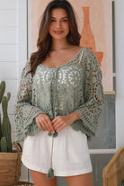 Woman wearing sage crochet boho top with dramatic bell sleeves - festival fashion Australia.